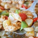 Metal spatula scooping up sweet and sour chicken from the sheet pan.