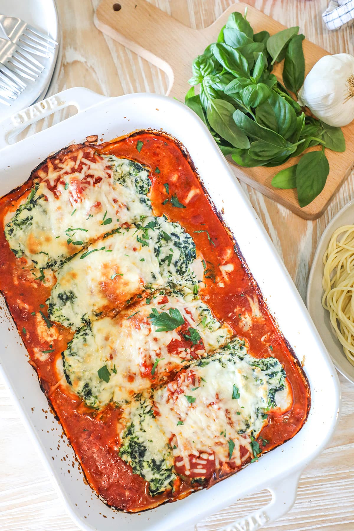 Overhead shot of a spinach ricotta chicken bake in a white baking dish.