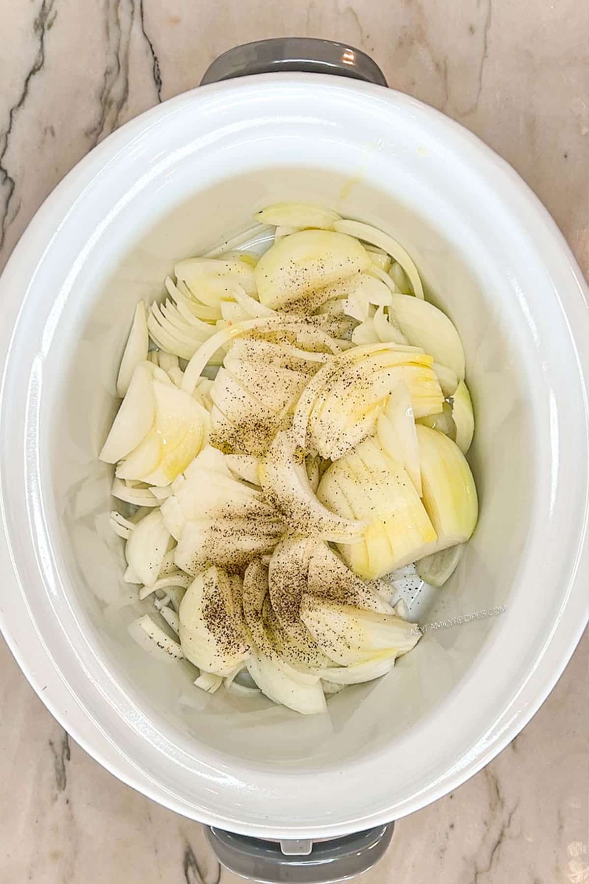 sliced onions in a crockpot.