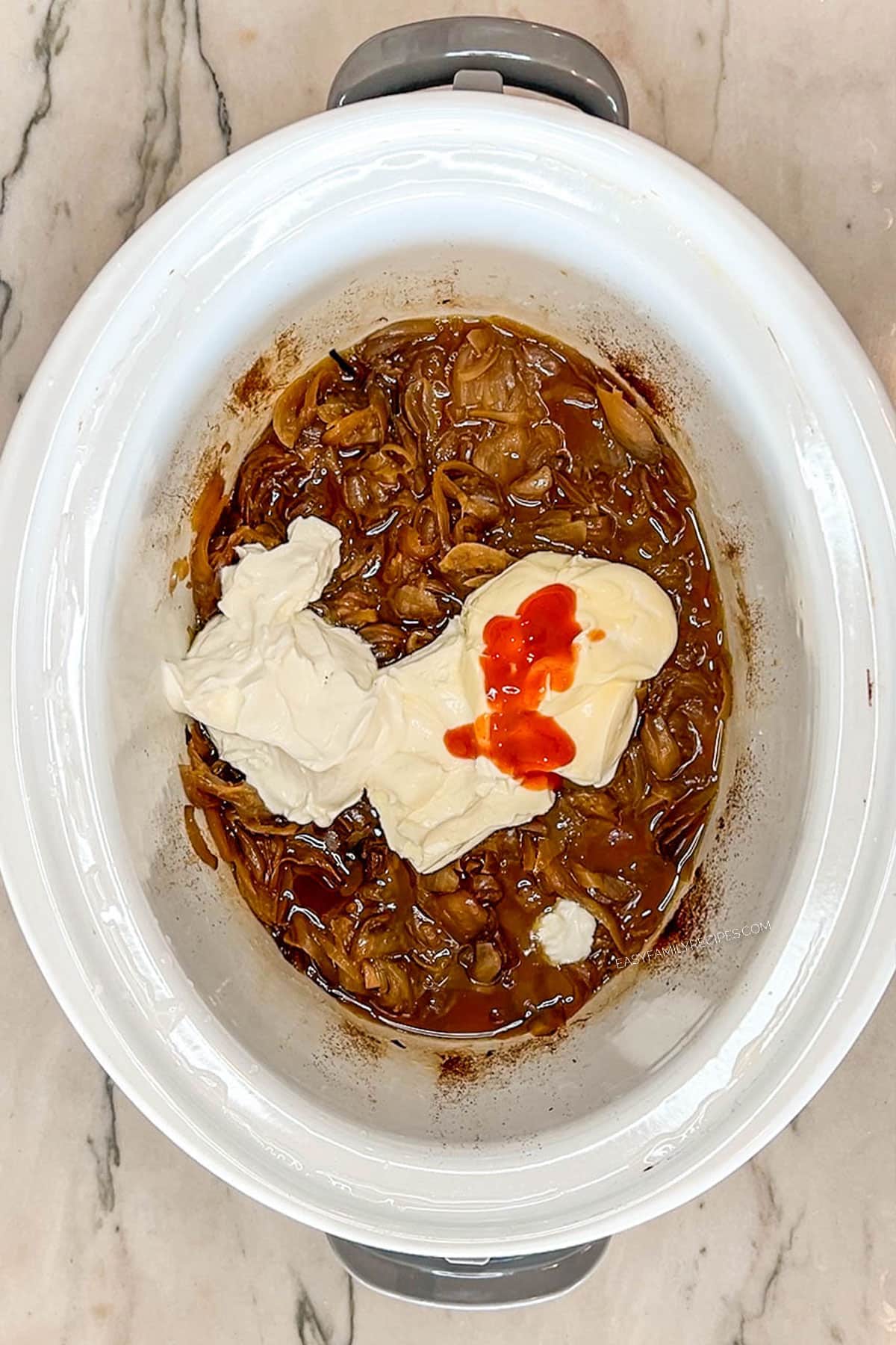 caramelized onion, sour cream, cream cheese, and hot sauce in a slow cooker.