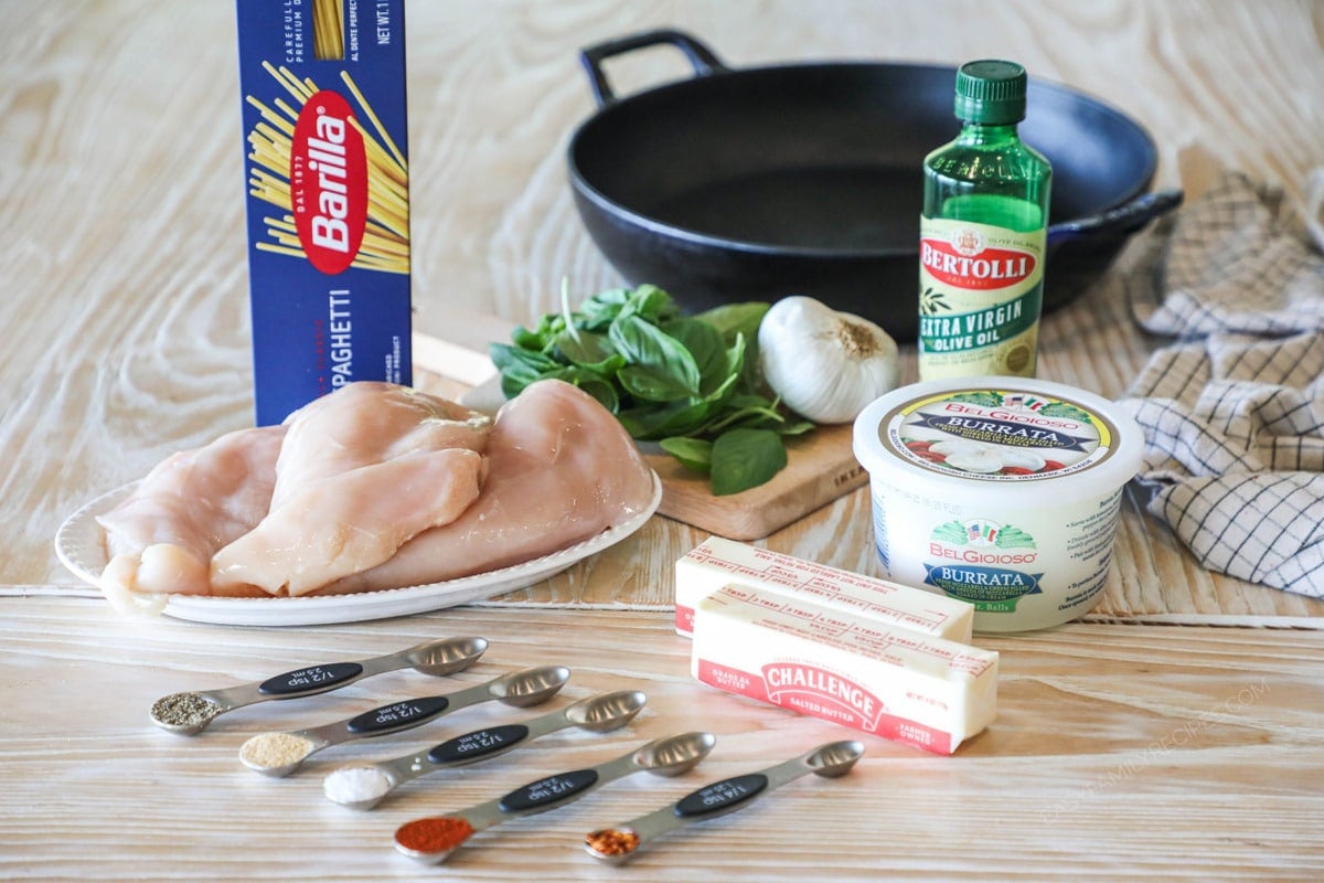 Ingredients needed to make brown butter spaghetti with chicken, basil and burrata. On a wooden background