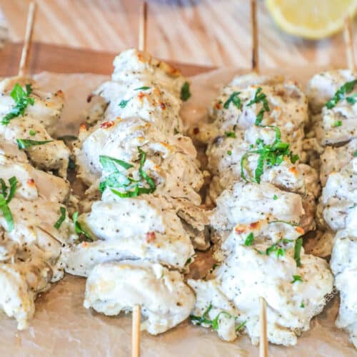 greek chicken gyro skewers on wooden board