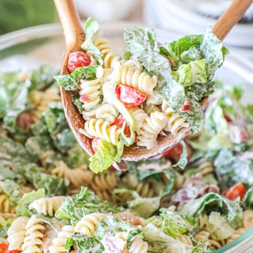 ranch pasta salad being served with salad tongs.