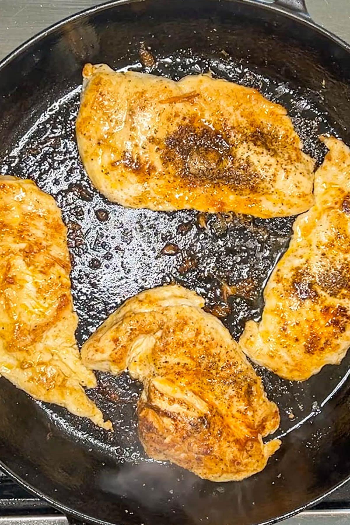 Pan with four cooked chicken breasts