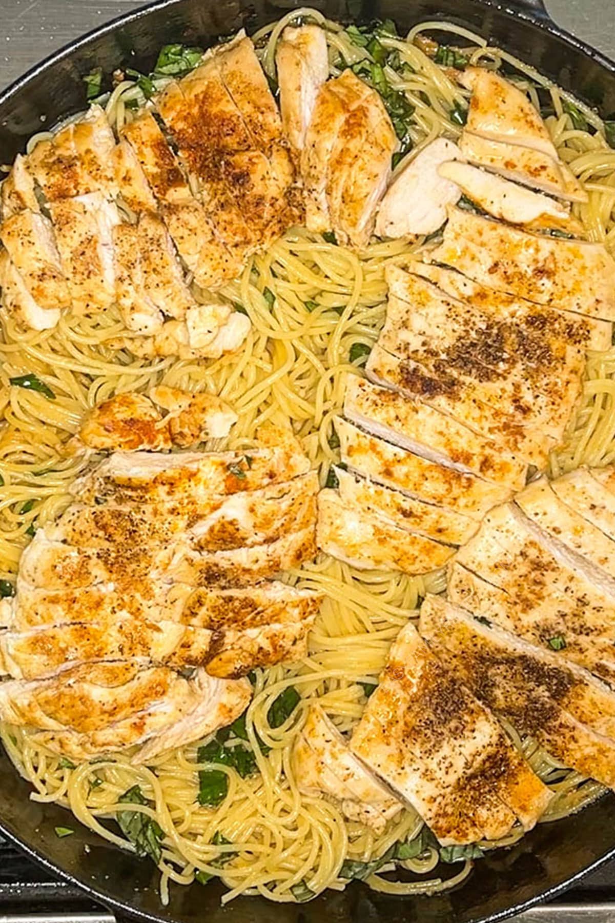 Brown butter spaghetti with chicken, basil and burrata in pan