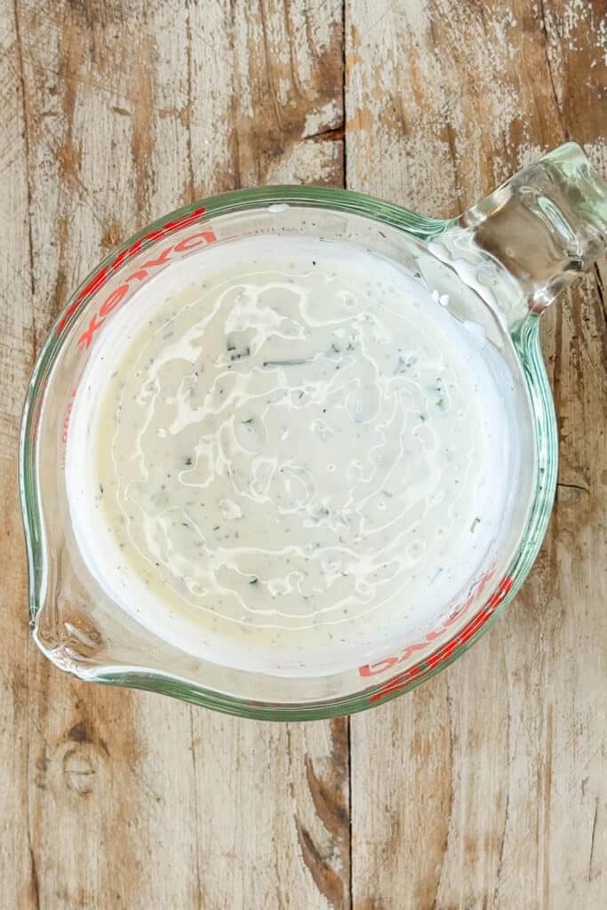 creamy pasta salad dressing in a measuring cup.