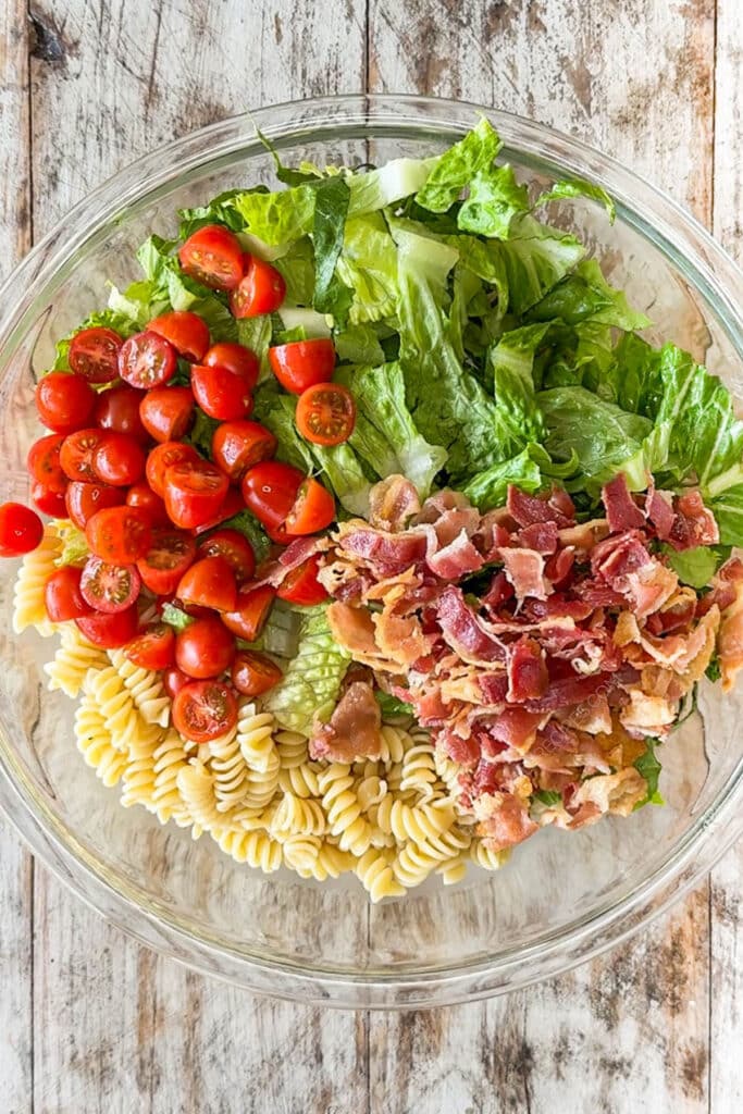 pasta, lettuce, tomato, and bacon in a bowl.