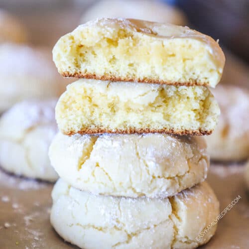 Lemon cake mix crinkle cookies stacked. Two half cookies on top. Cookies in background