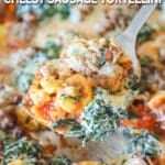 Spatula holding up a portion of cheesy sausage tortellini from the sheet pan.