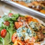 Side view of cheesy sausage tortellini served on a plate with a side salad.