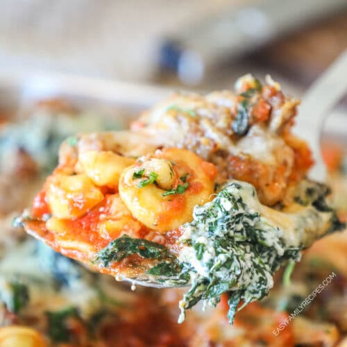 Close up of a portion of cheesy sausage tortellini on a metal spatula.