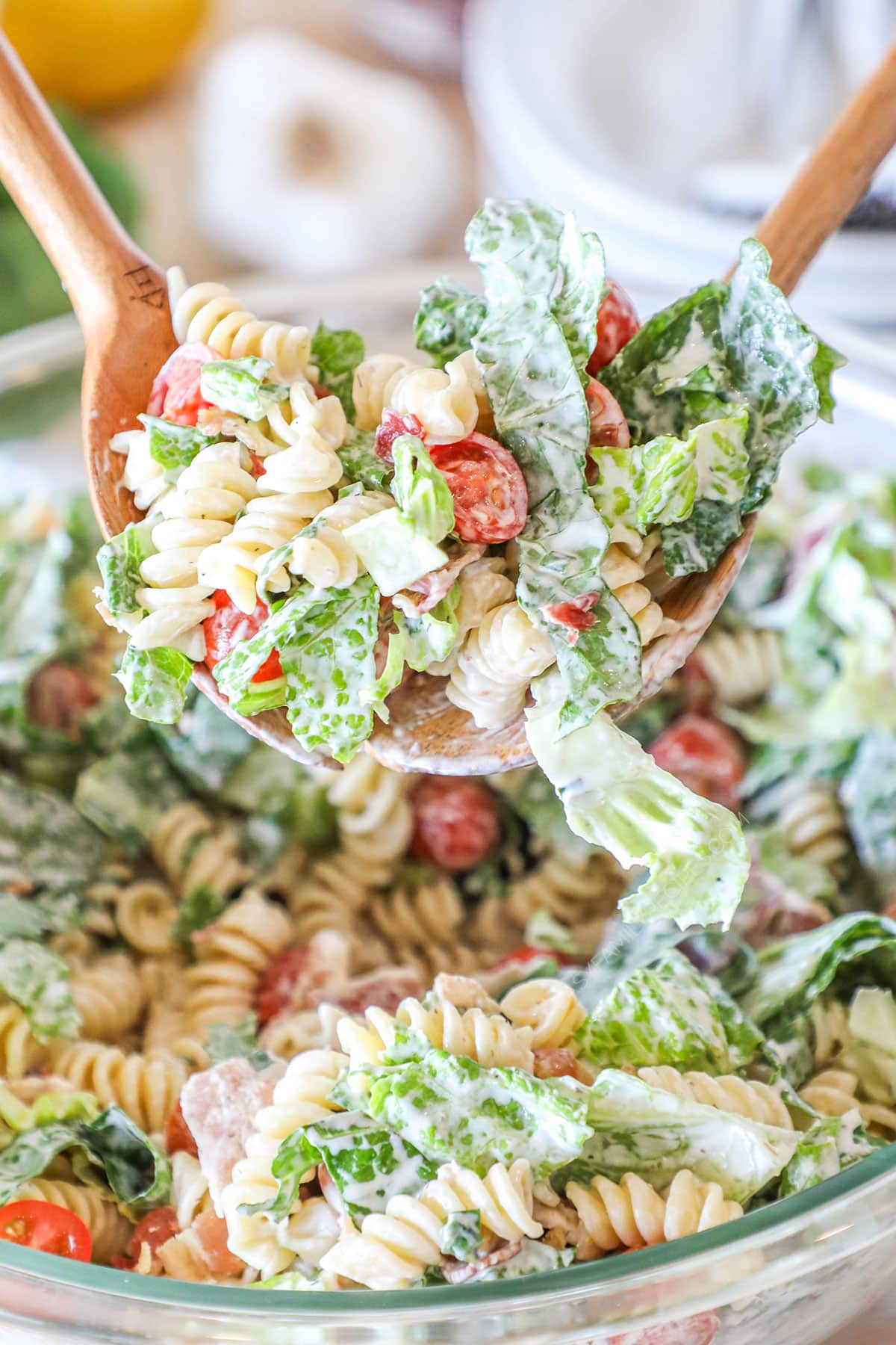 ranch pasta salad being served with salad tongs.