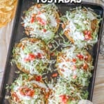 above image of 6 finished chicken and bean tostadas on a baking sheet.