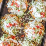 above image of baked tostadas piled with lettuce and tomato.
