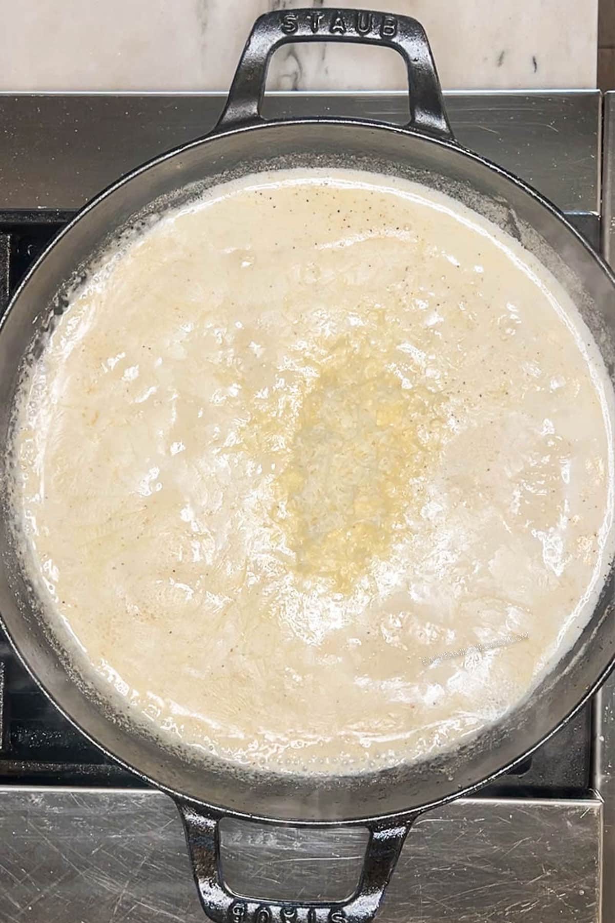 Creamy smothered chicken sauce in pan on stove