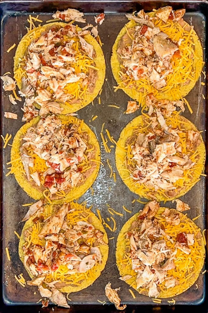 six shells layered with beans, cheese, and chicken.