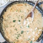 Large pan of smothered chicken. White bowl with rice and fresh herbs in background. On a wooden table