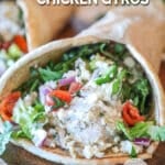 Side view of a chicken baked gyro with feta, tzatziki and veggies.