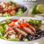 Side view of a carne asada bowl topped with guacamole and pico de gallo.