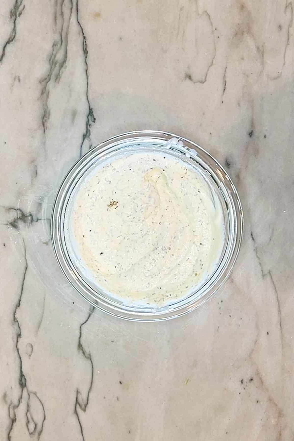 Ricotta cheese mixed with cream cheese, sour cream, and Italian seasoning in a bowl.