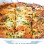 Close up of baked million dollar ravioli sliced into squares and garnished with parsley.