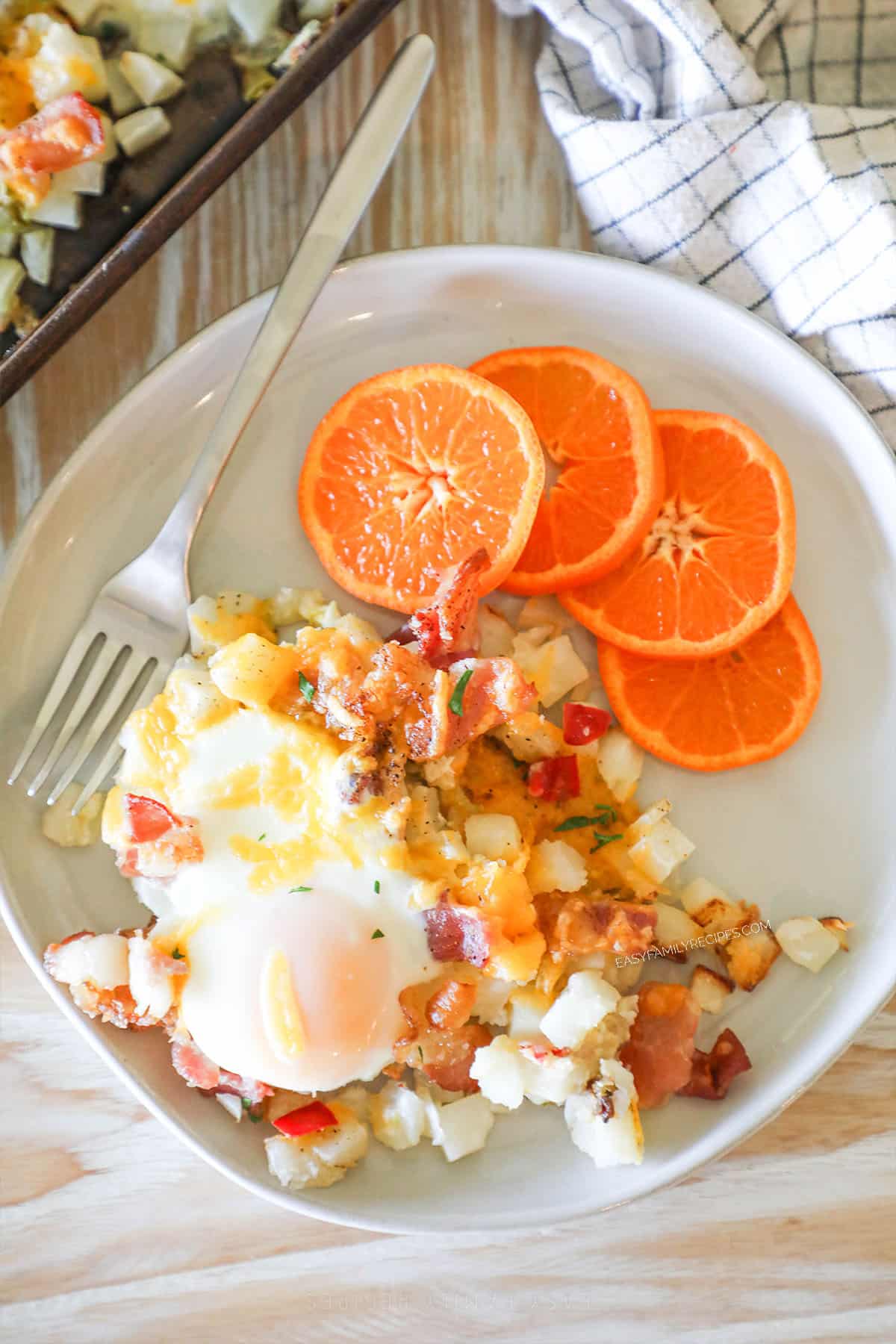 above image of a plate full of breakfast hash browns and orange slices.