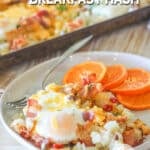 bacon egg breakfast hash on a plate with orange slices.