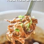 Spoonful of crockpot huli huli chicken garnished with green onions.