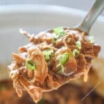 Close up of a serving spoon with crockpot huli huli chicken on it.