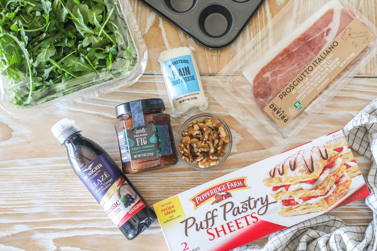 Ingredients needed to make Goat Cheese and Fig Jam Puff Pastry Bites- on a wooden background