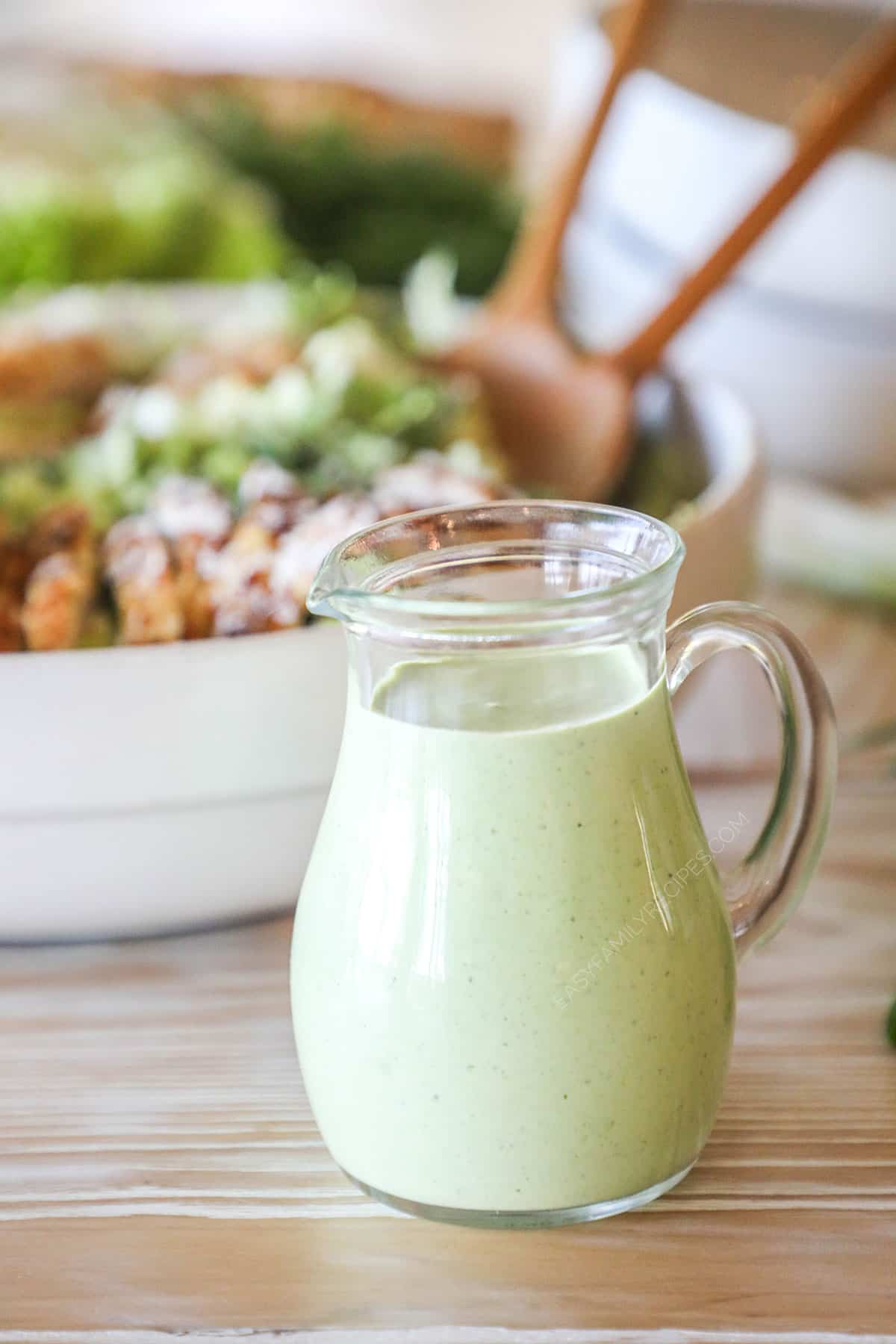 homemade green goddess dressing in a glass pitcher.