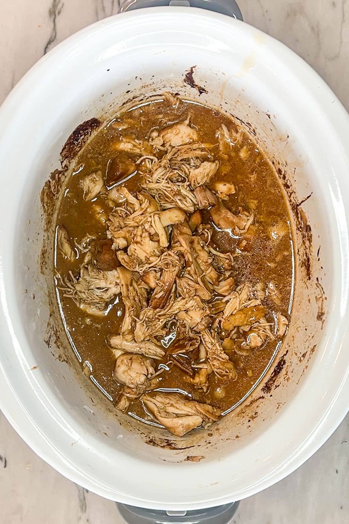 Shredded huli huli chicken added back to the crockpot.