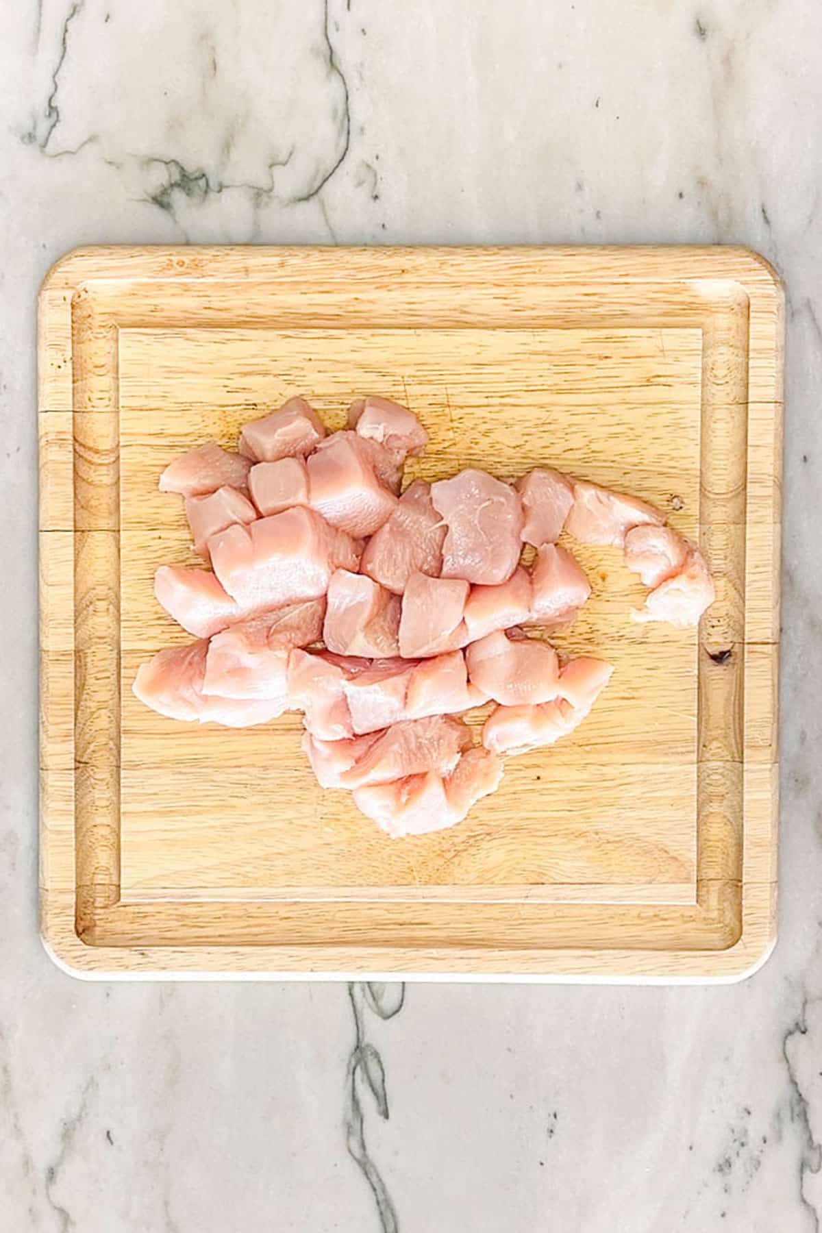 Diced chicken breast on a cutting board.