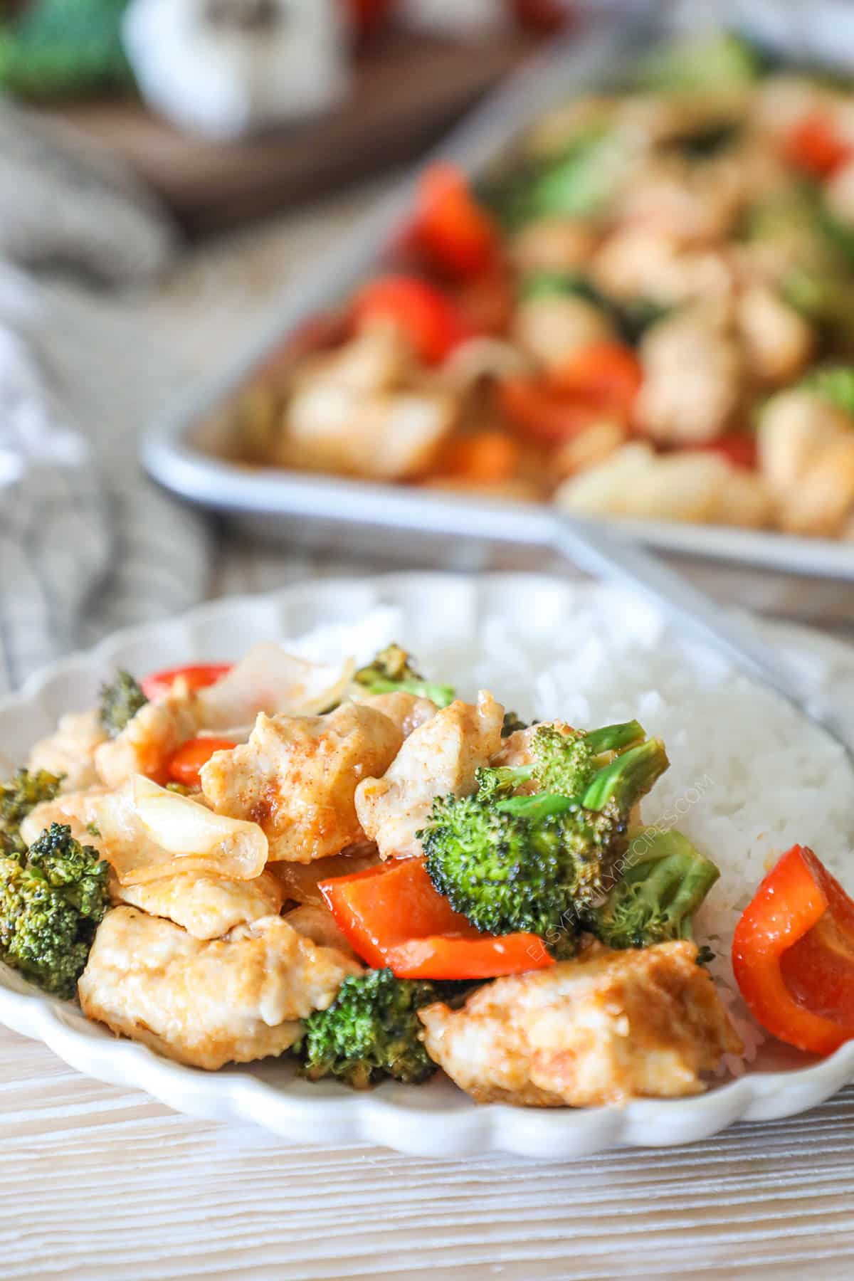 Sheet pan hot honey chicken served on a white plate with rice.