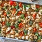 Finished sheet pan hot honey chicken with veggies in the baking sheet.