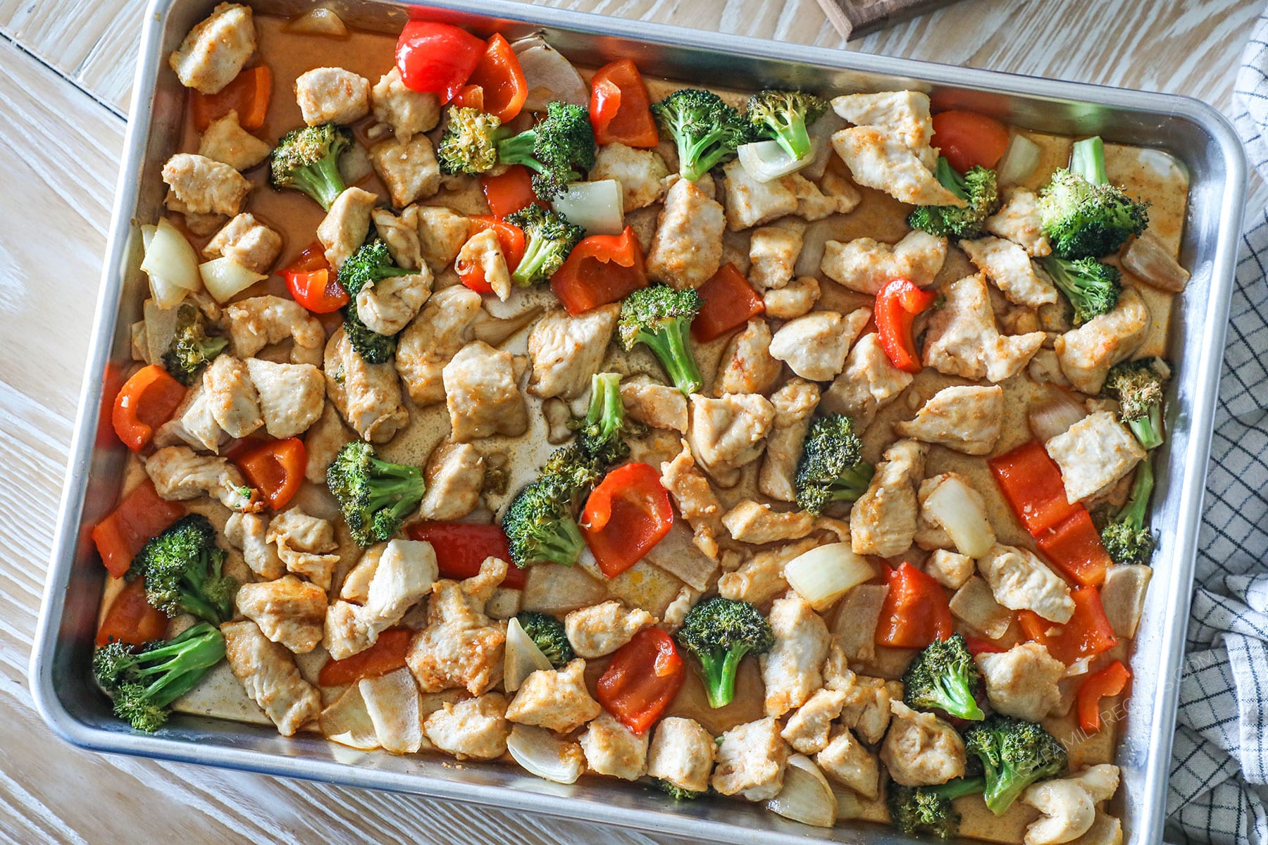 Finished sheet pan hot honey chicken with veggies in the baking sheet.