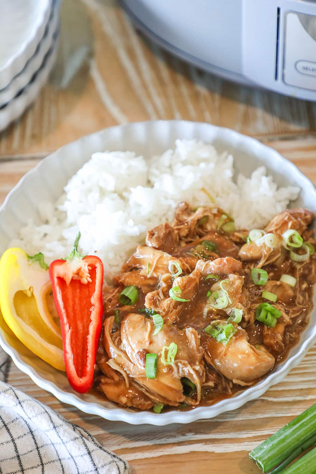 Juicy huli huli chicken served on a plate with rice and sweet peppers.
