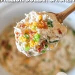 Crockpot Million Dollar Chicken- in a white crockpot- being lifted out by wooden spoon