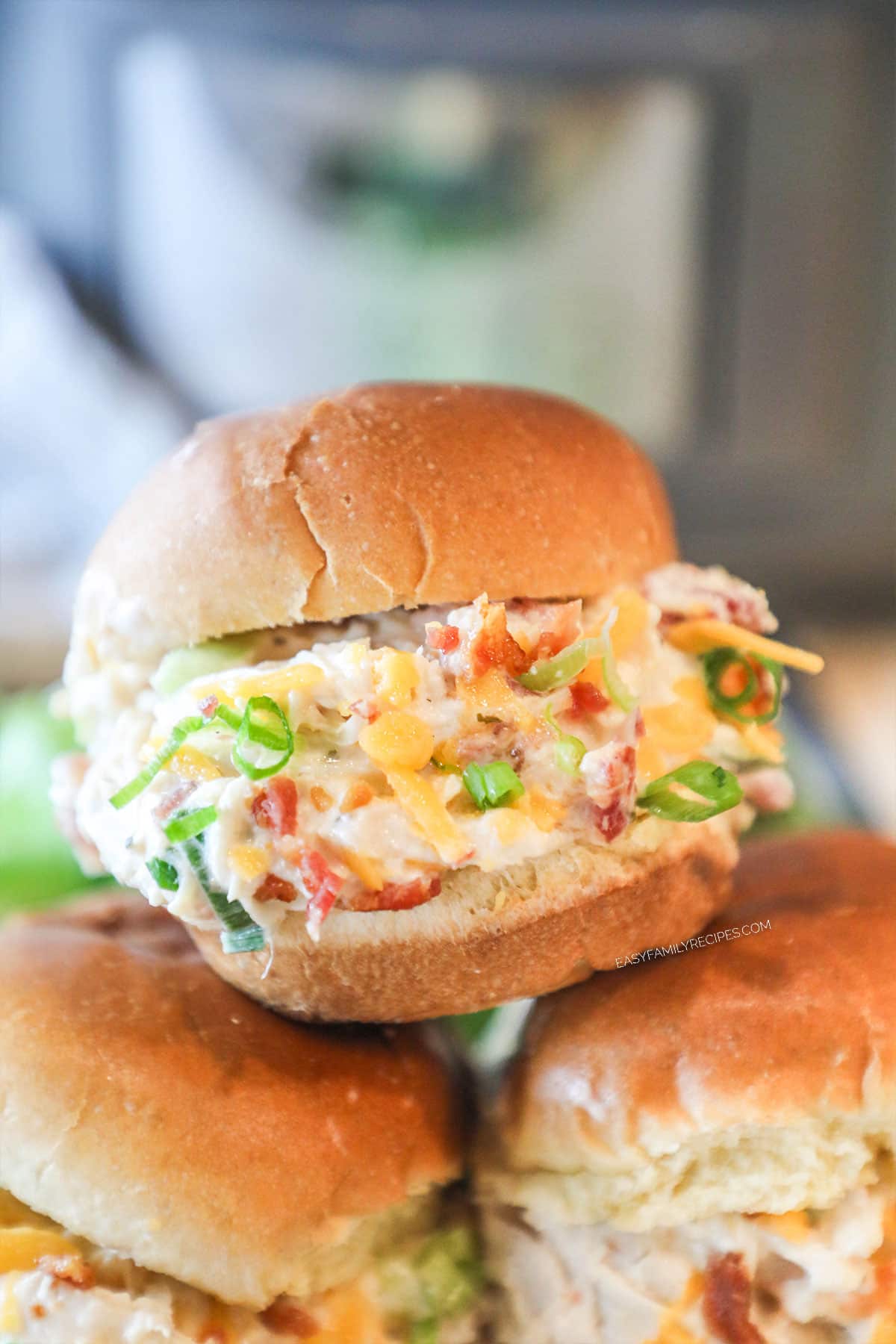 Crockpot Million Dollar Chicken stuffed into sliders- 3 slider sandwiches piled together