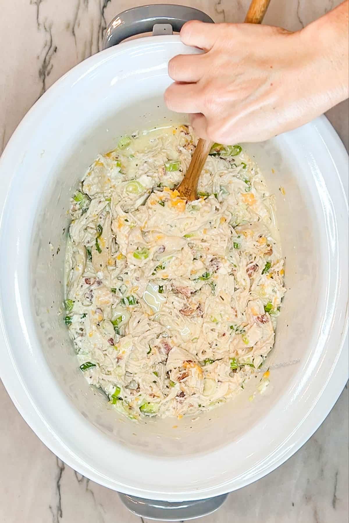 Step 6 for making Crockpot Million Dollar Chicken- Mix all together. In a white crockpot