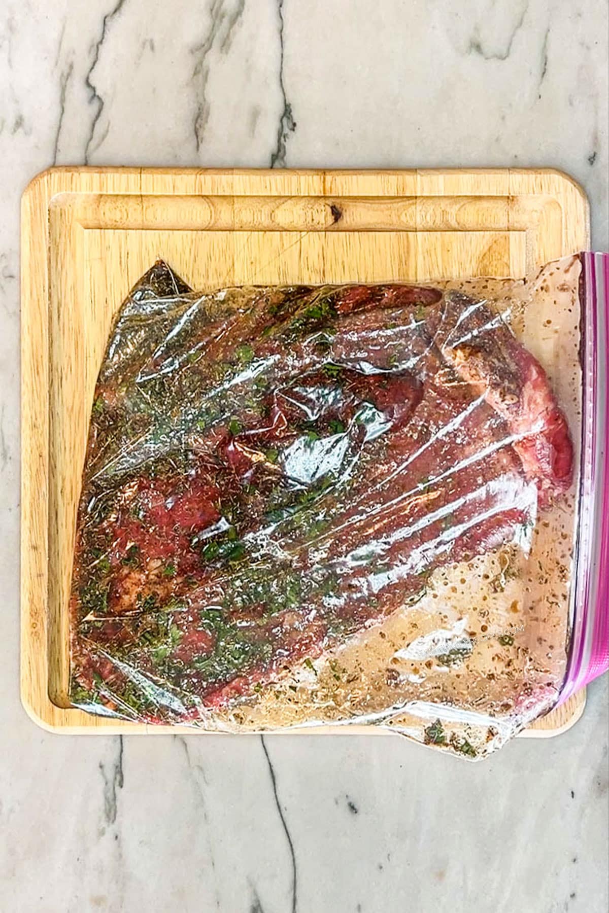 Step 2 for how to make flank steak marinade- add steak to bag and cover with marinade