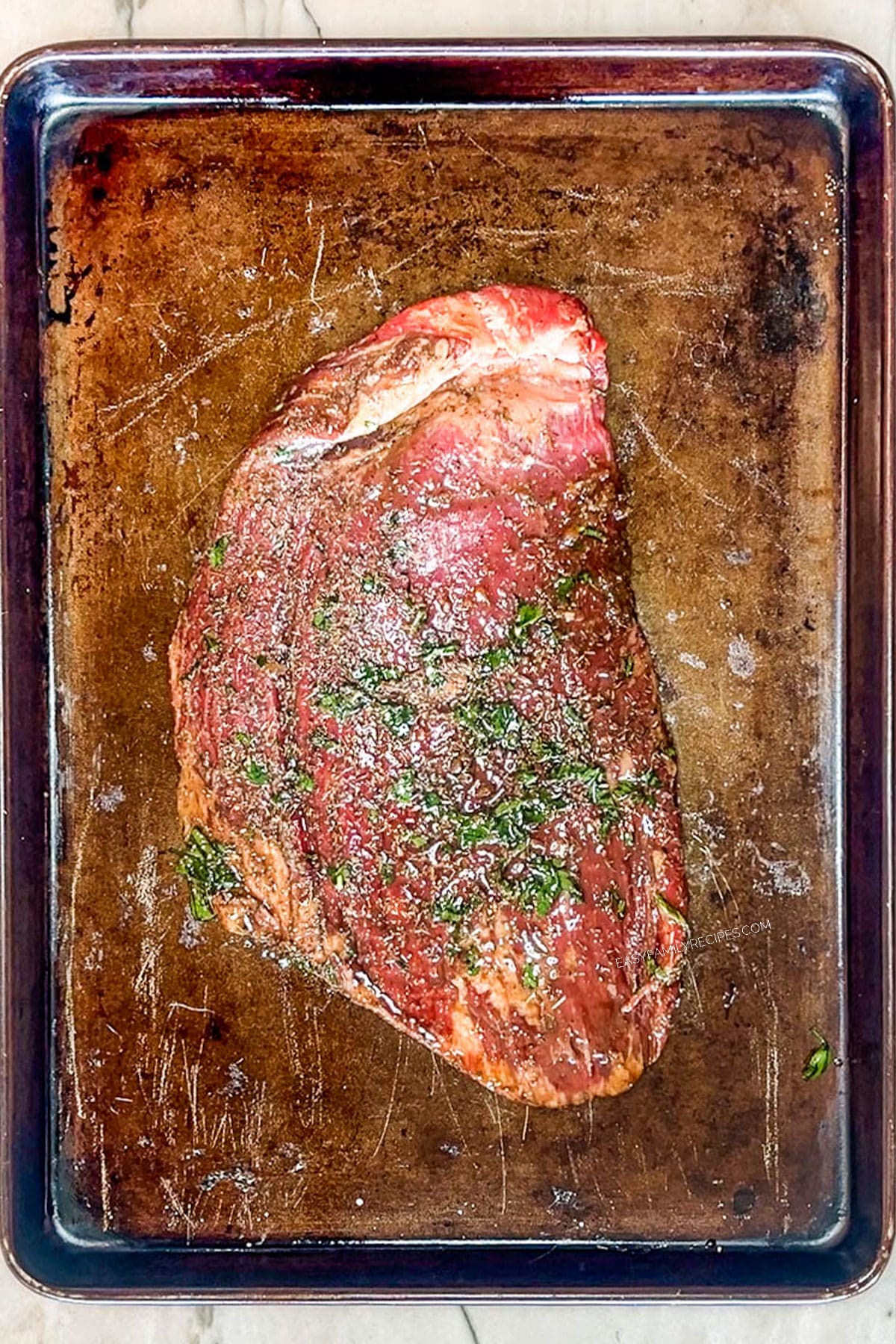 Step 4 for how to make flank steak marinade- place steak on baking sheet