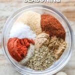 The various spices for Carne Asada Seasoning Blend in a clear bowl on a wooden background