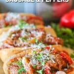 Three Italian sausage and peppers sandwiches on foil.