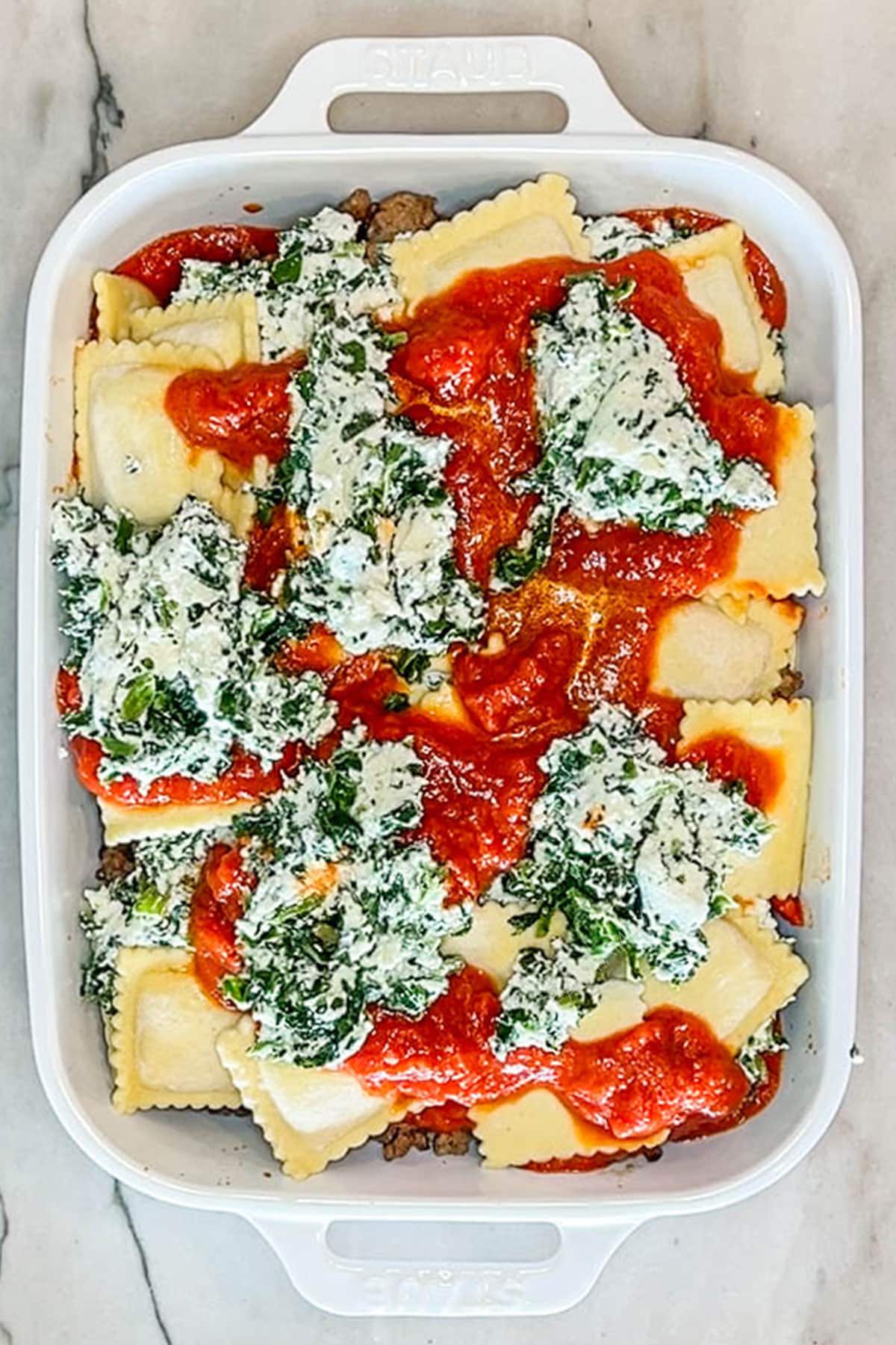 Ricotta spinach mixture placed on top of the layers of sauce and ravioli.