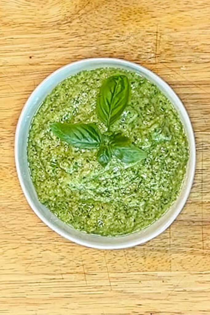 homemade pesto garnished with fresh basil in a bowl from above.