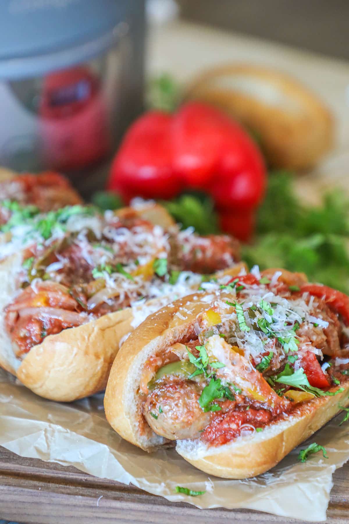 Side view of sausage and peppers served in hoagie rolls.