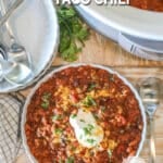 Overhead shot of a bowl or crockpot taco chili garnished with sour cream.
