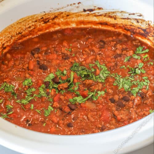 Finished crockpot taco chili in the slow cooker garnished with cilantro.