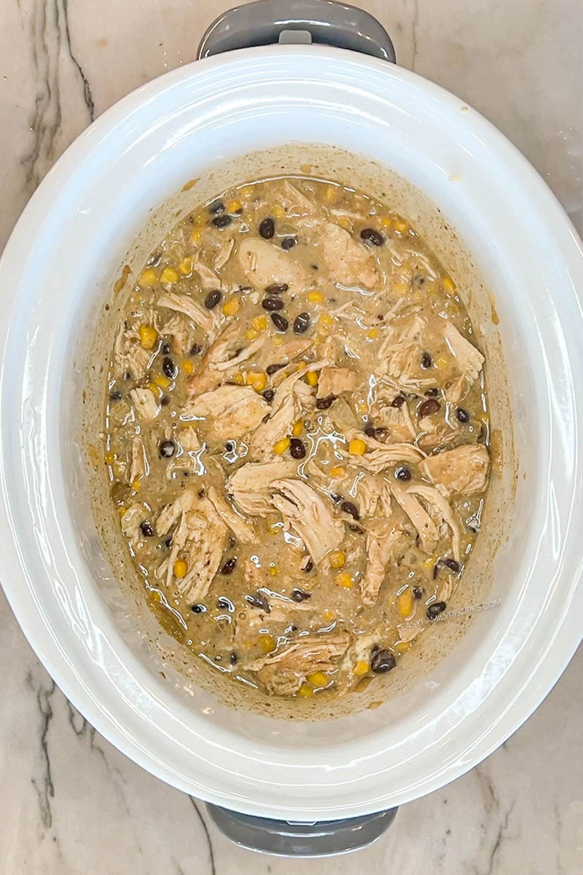 Green chicken enchilada mixture combined in a crockpot.